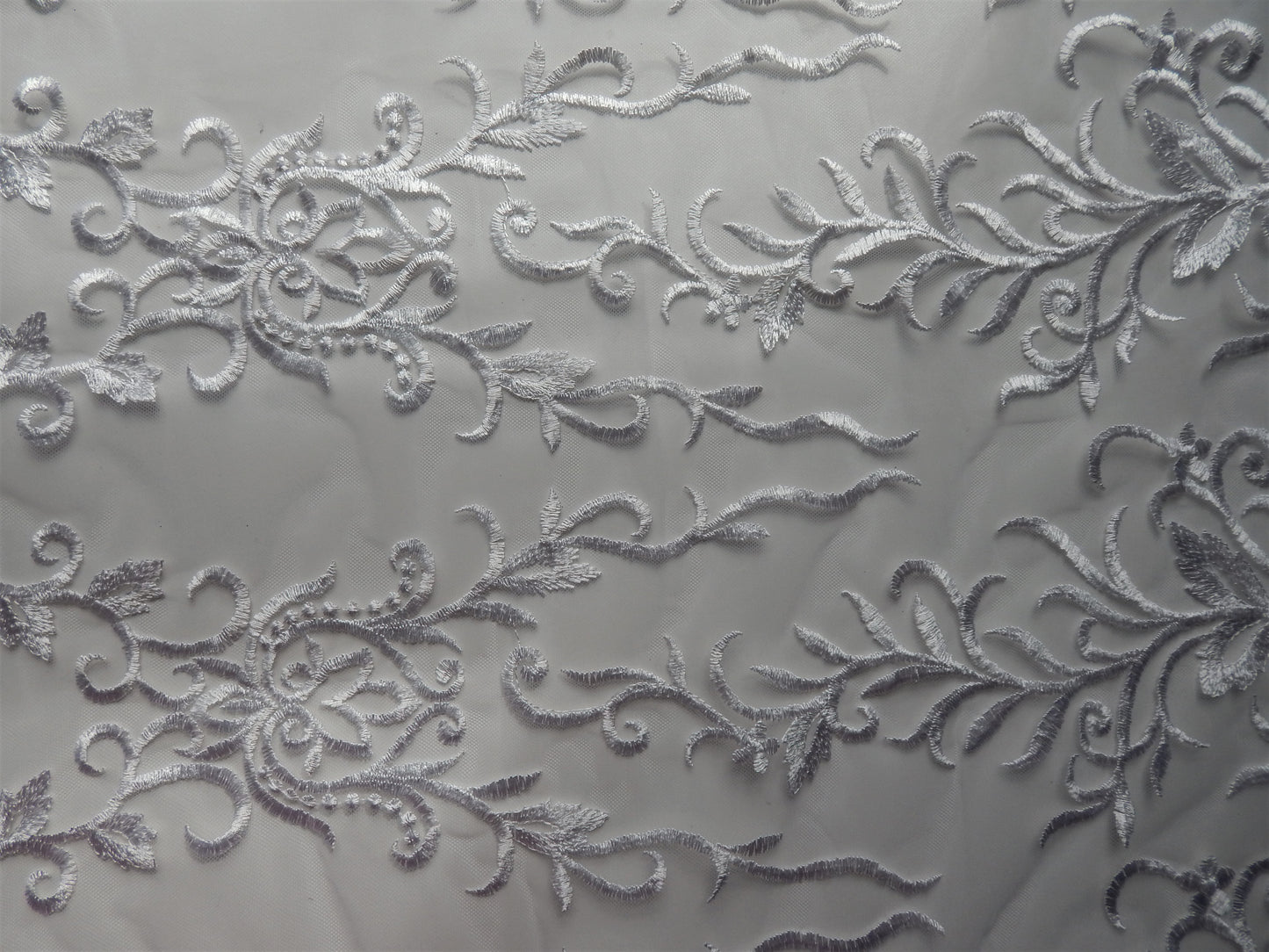white embroidered scroll and vine lace fabric