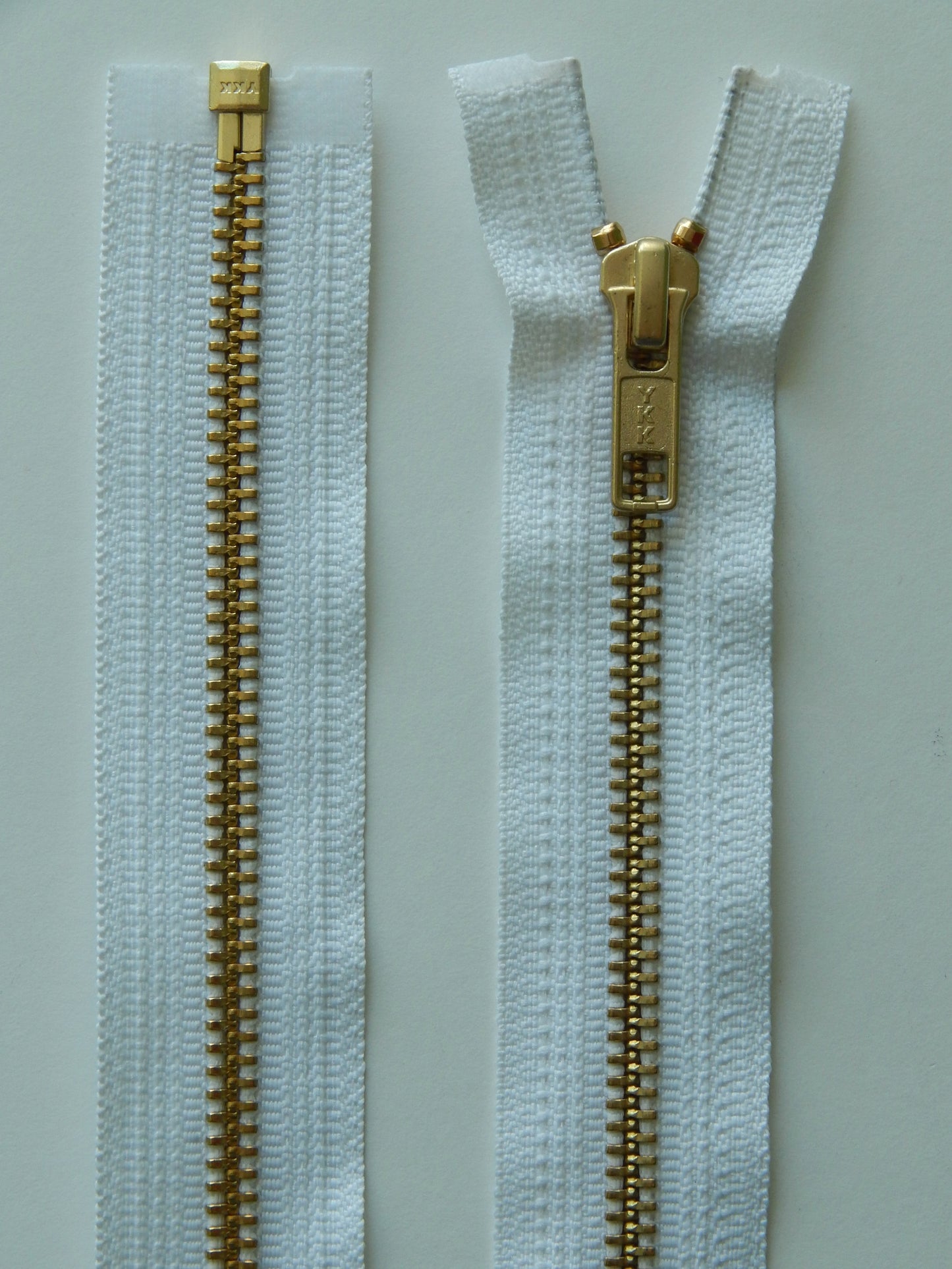 white and brass gold separating jacket zipper