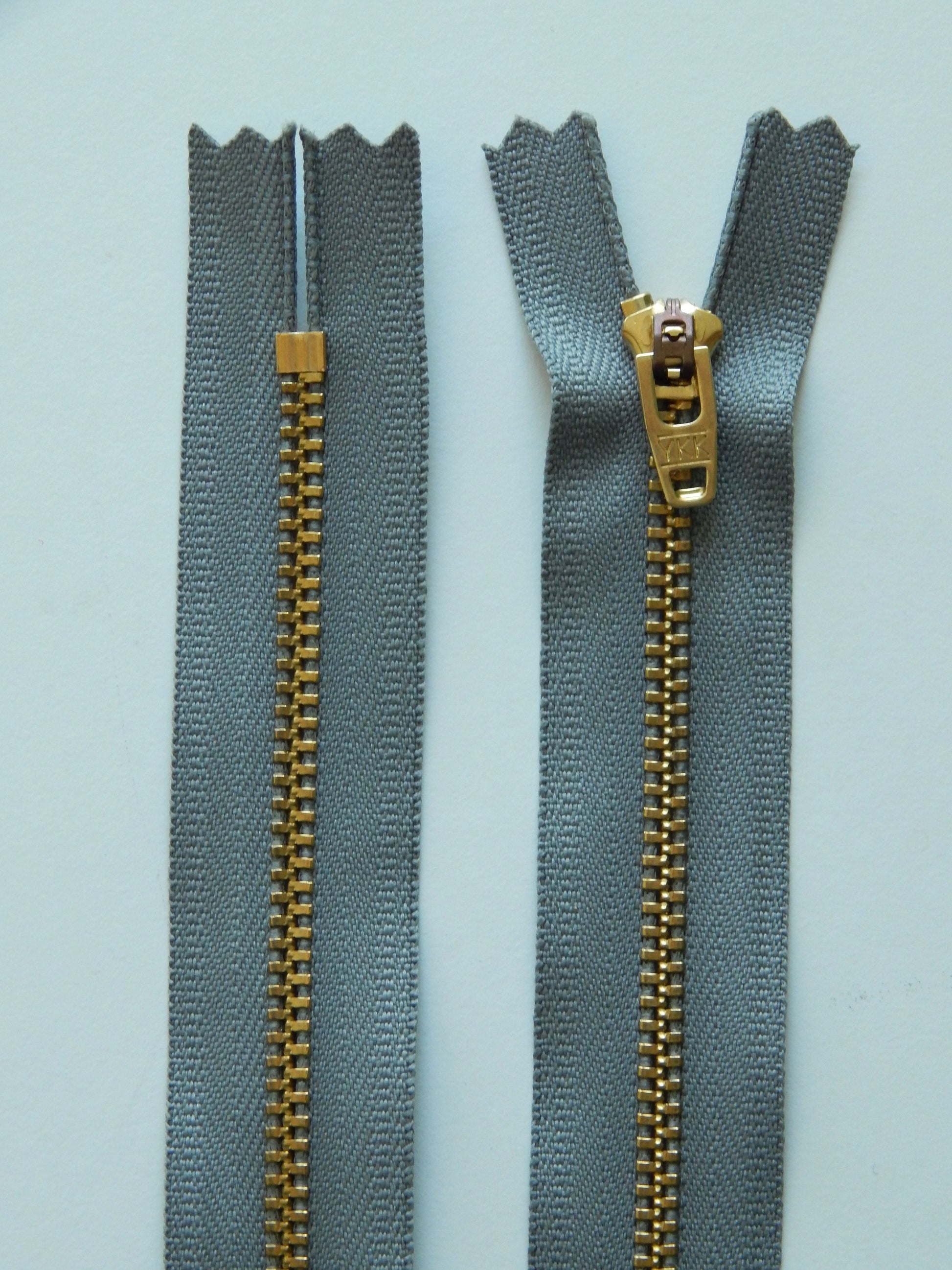 gray and brass nonseparating pant zipper