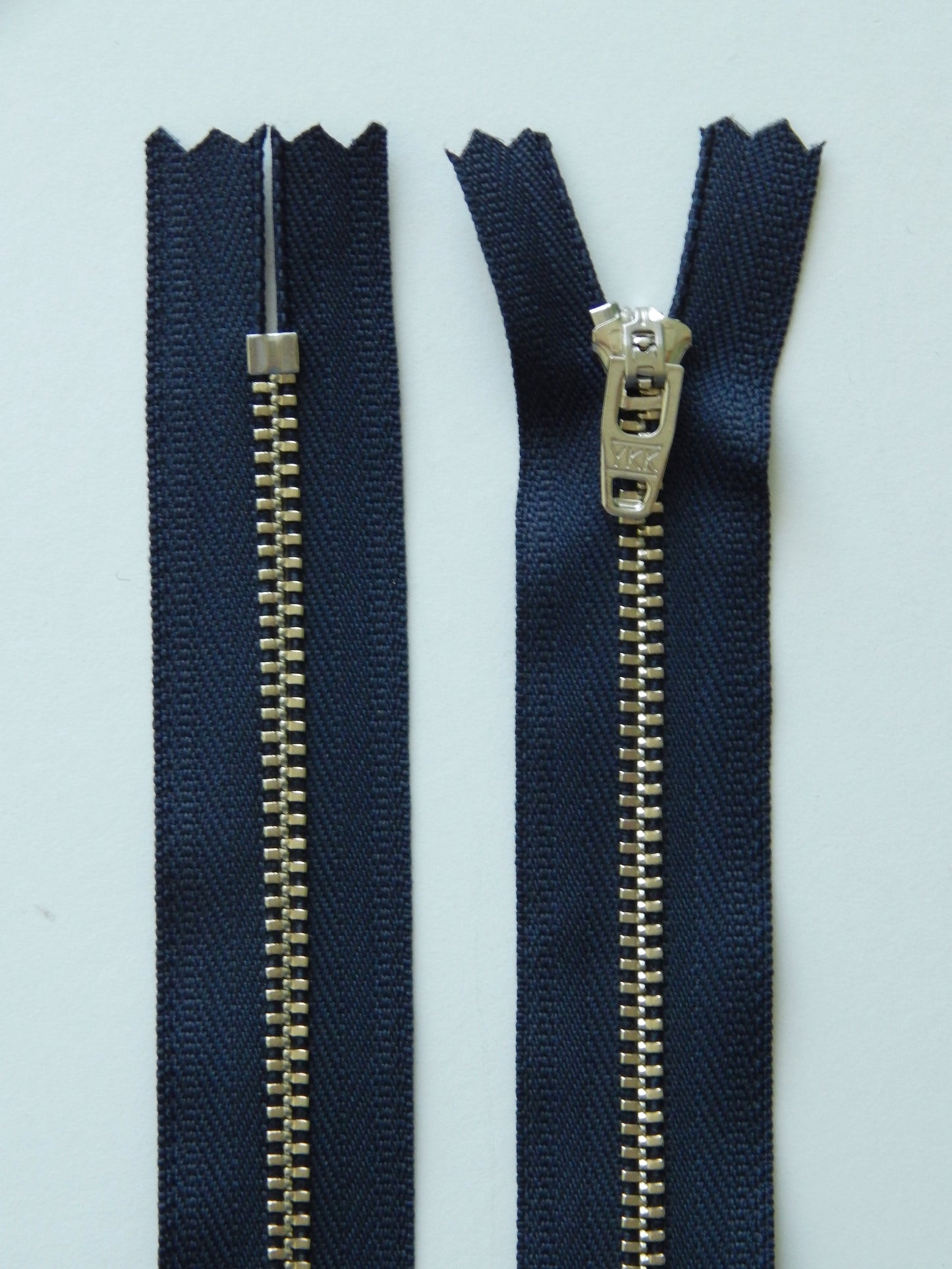 dark blue and silver metal nonseparating pant zipper