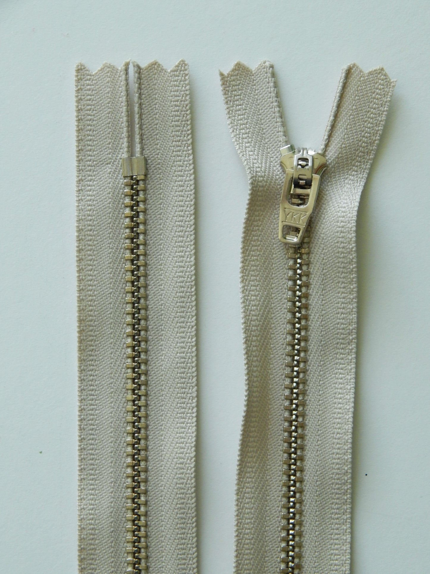 beige and silver metal nonseparating pant zipper